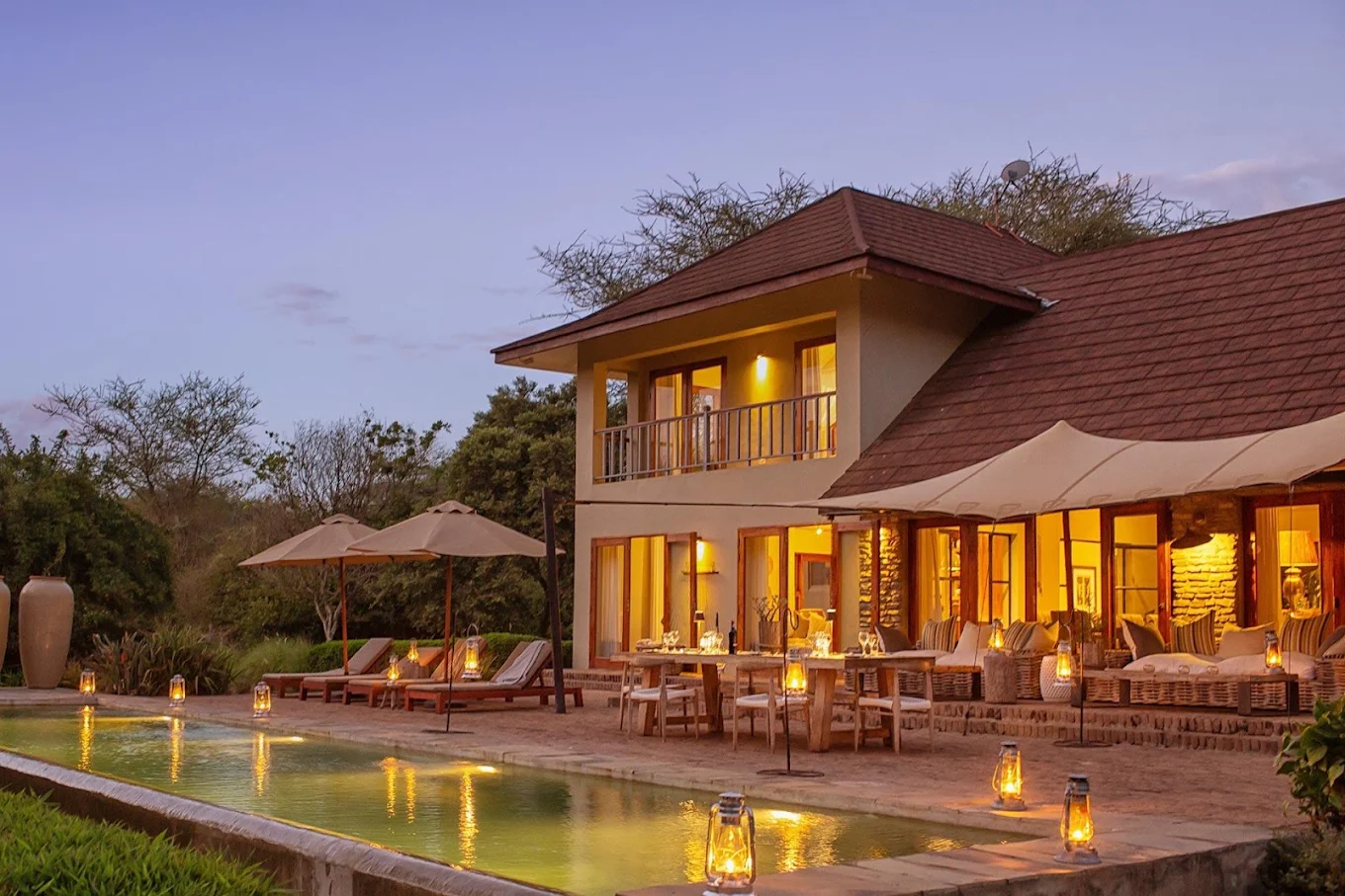 Siringit Villa at dusk, lantern-lit terrace and pool beside the private villa near Arusha, Tanzania