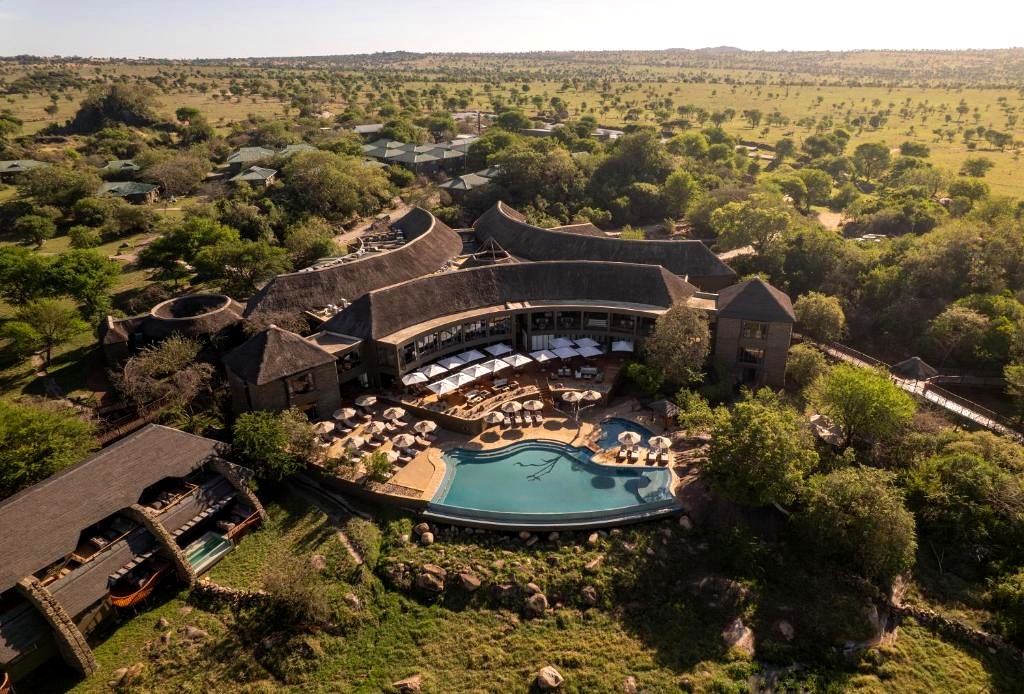 Four Seasons Safari Lodge Serengeti, aerial view of curved thatched roofs, infinity pool and sun terrace overlooking the Serengeti plains