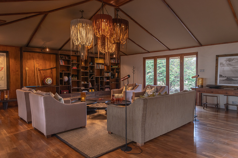 Closed: Apr 1–May 31. Sayari Camp main area lounge interior, elegant canvas tent lounge with woven chandeliers, sofas and wooden shelving in the North Serengeti