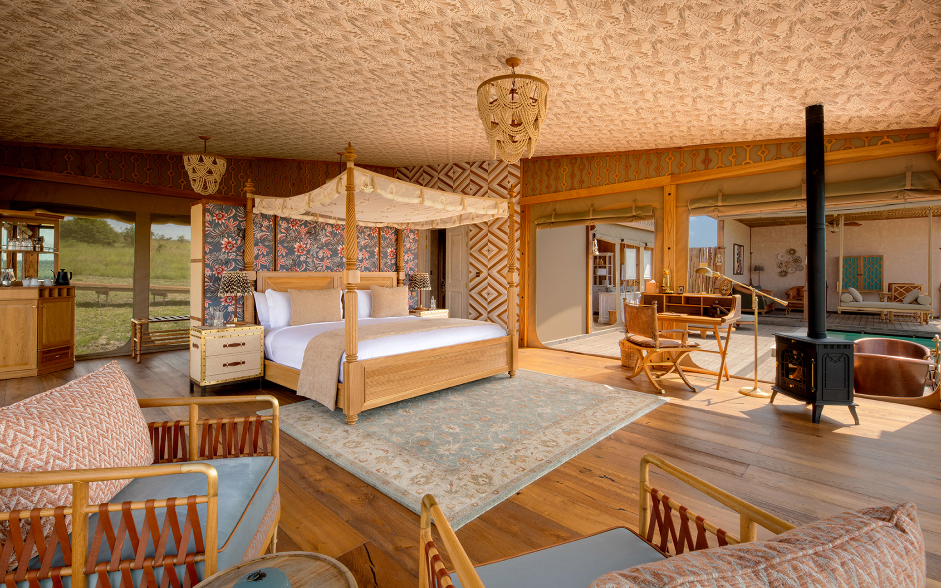 One Nature Mara River luxury tent interior, four-poster bed, wood stove and copper bathtub with Mara River views