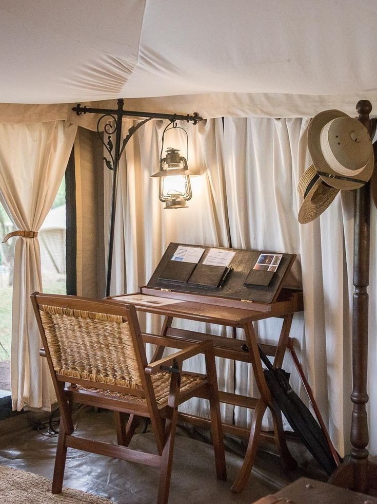 Writing desk with a lit lantern inside a safari tent
