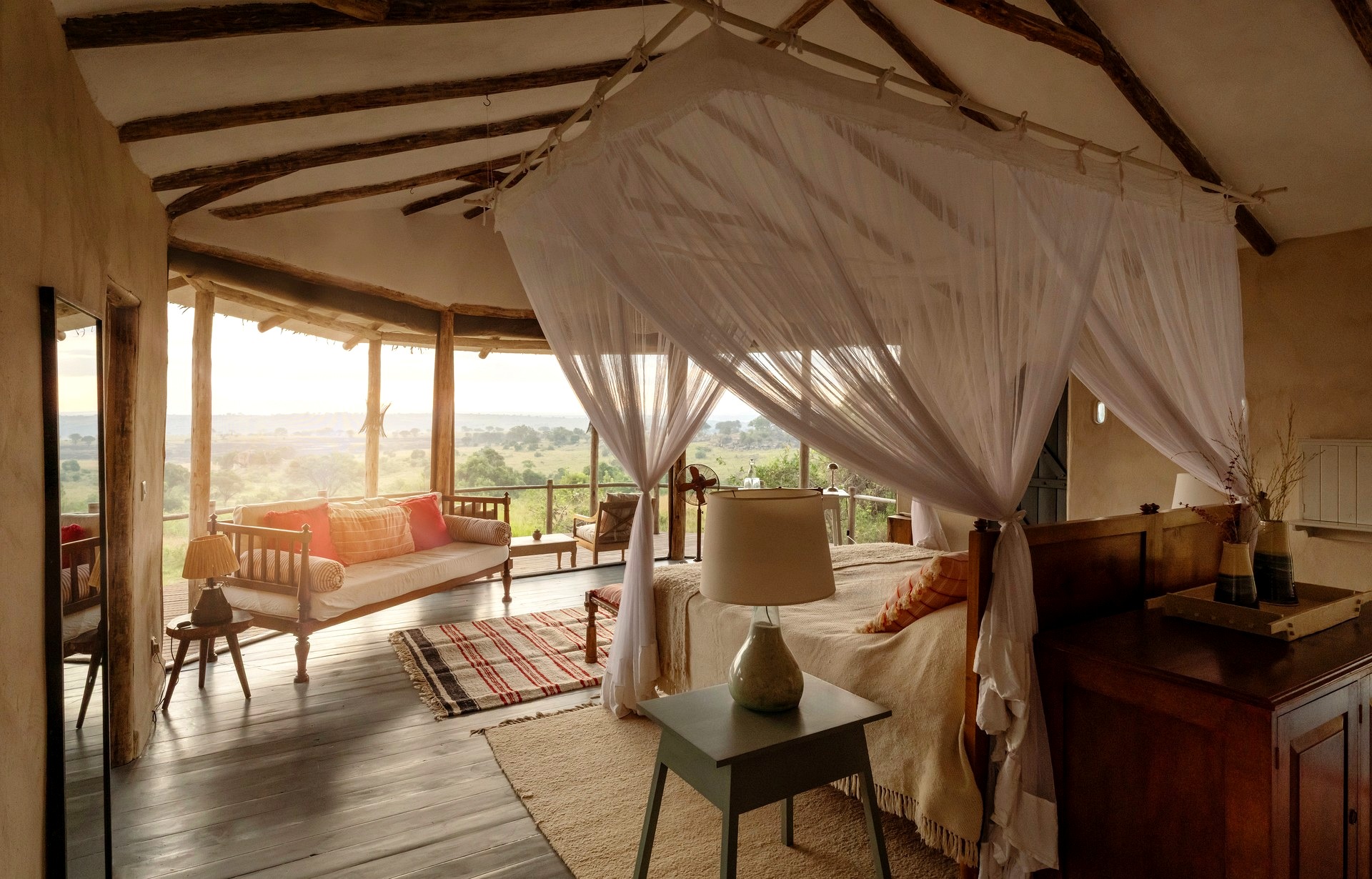 Closed: Mar 18–May 31. Lamai Nomad luxury tent interior, four-poster bed with flowing mosquito nets, private veranda and sweeping Serengeti views