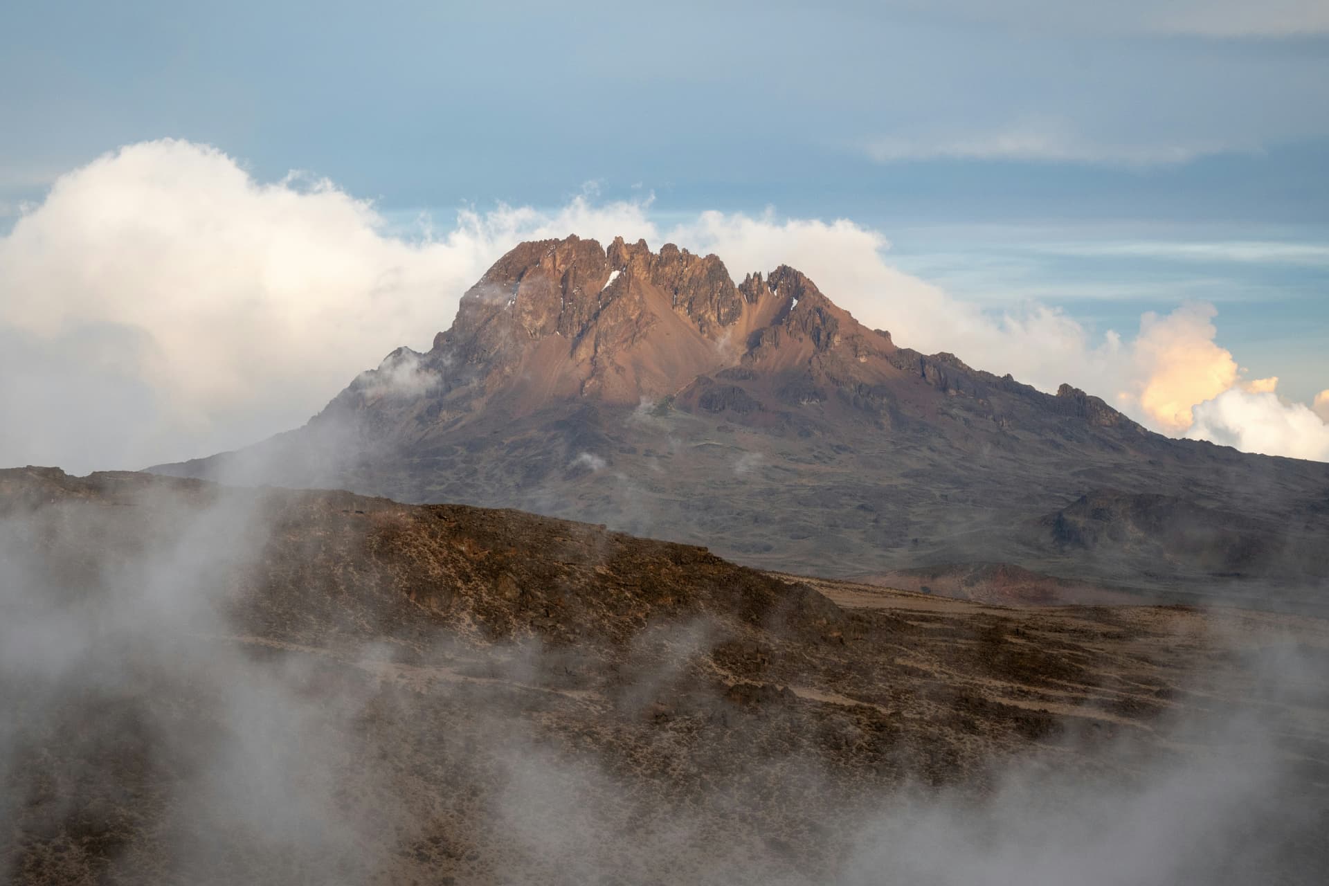 Mount Kilimanjaro rising above clouds at golden hour